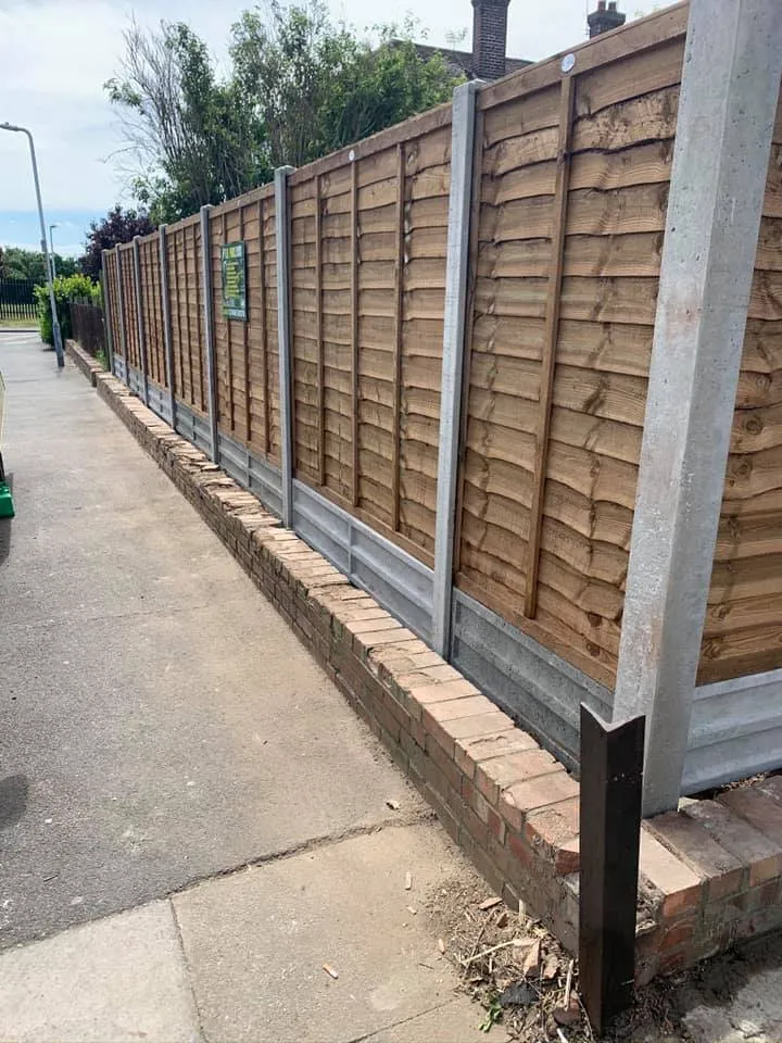 A row of wooden fences next to a sidewalk.