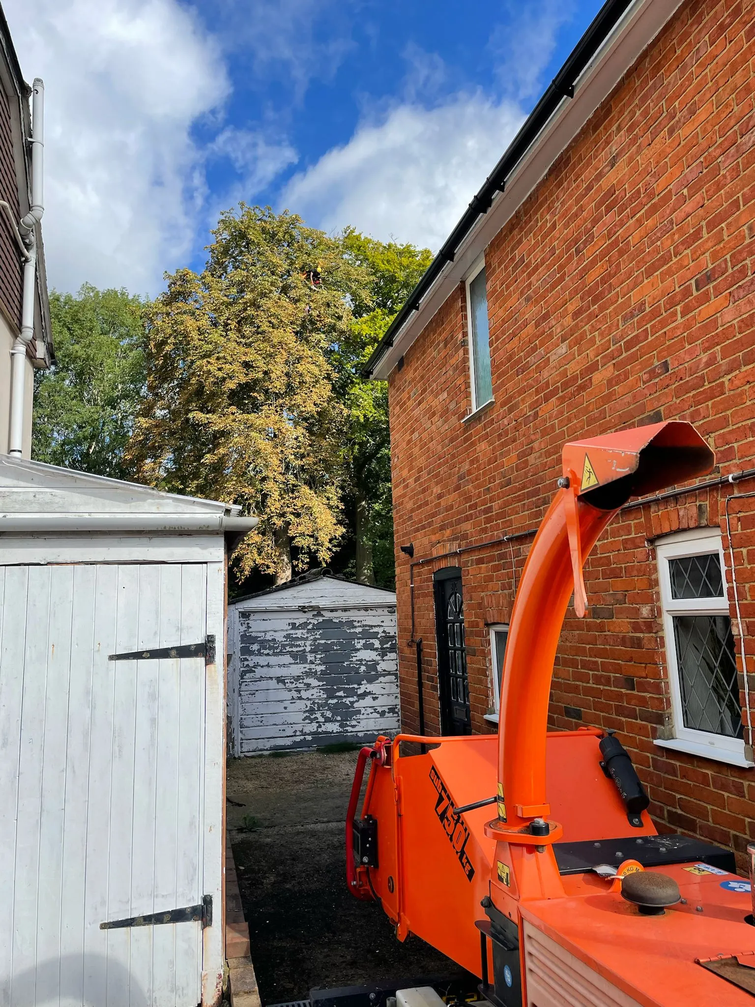 An orange boat sitting next to a brick building.