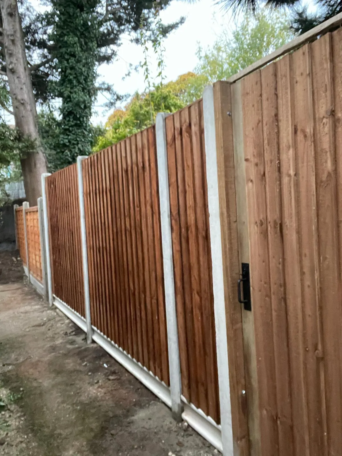 A wooden fence with a metal gate on top of it.